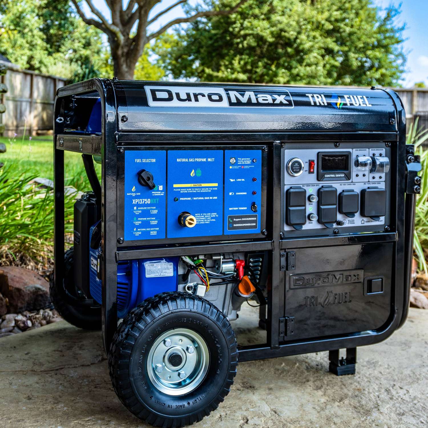 DuroMax XP13750HXT tri-fuel generator in a backyard garden