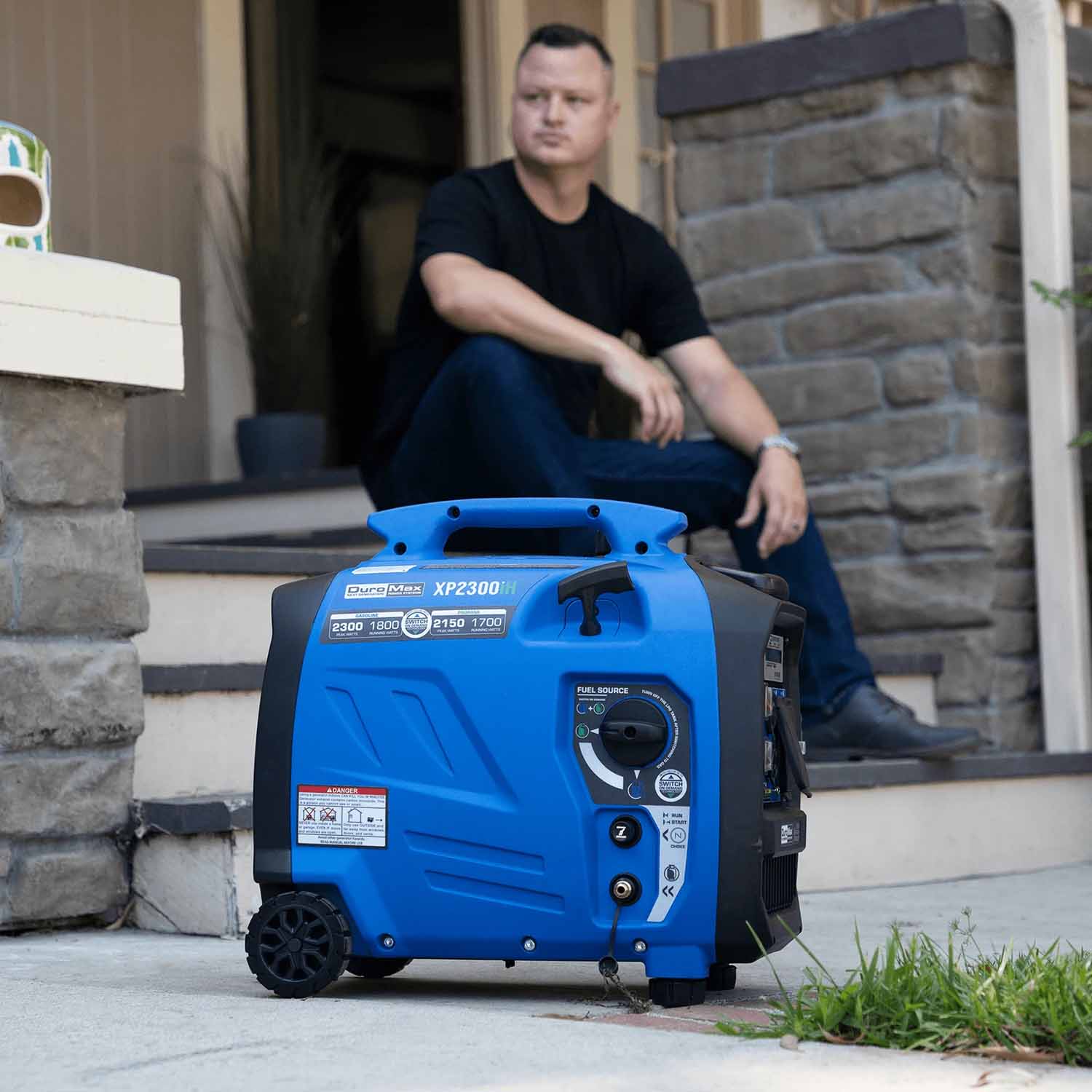 DuroMax XP2300iH Generator In Front Of A House With A Man Sitting