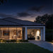 Home with its lights on at night and an EcoFlow TITAN beside a wall-mounted panel in the garage