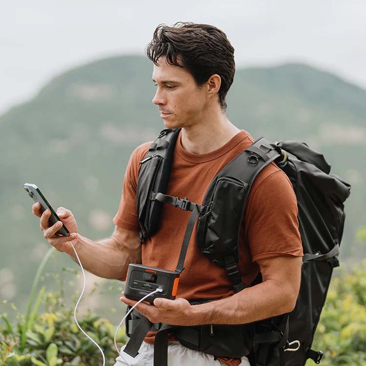 Man Carrying The Jackery Explorer 100 Plus While Hiking