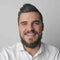 Smiling Outbound Power expert in a white shirt, ready to help by phone or email