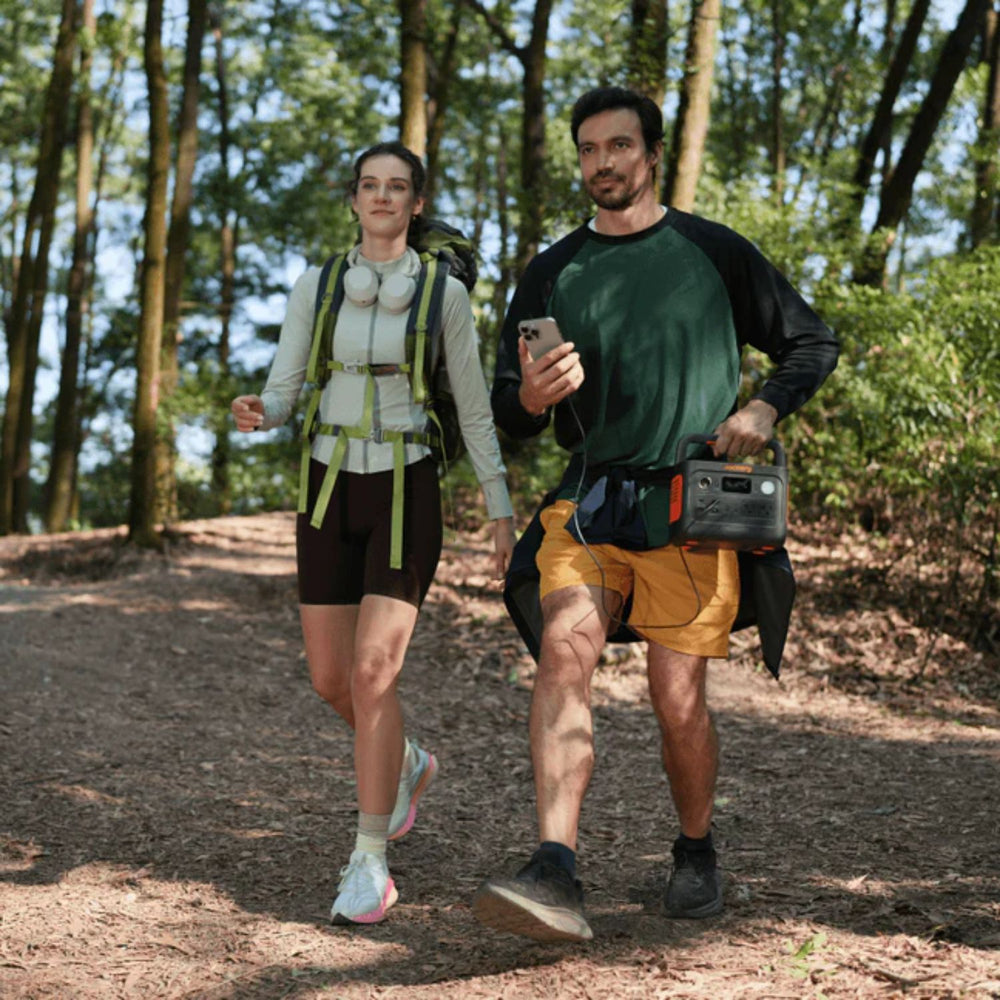 two person hiking and one person holding the Jackery Explorer 300 v2 Portable Power Station